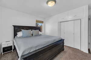 Bedroom featuring dark carpet and a closet