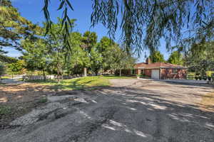 View of front of home with driveway, a chimney, and a garage