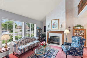 Living room featuring a fireplace and high vaulted ceiling
