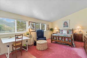 Upstairs bedroom with ample space and lofted ceiling