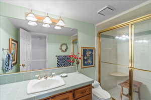 Bathroom featuring a shower stall, vanity