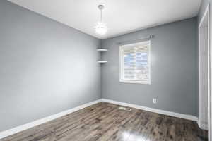Spare room with baseboards and dark wood finished floors