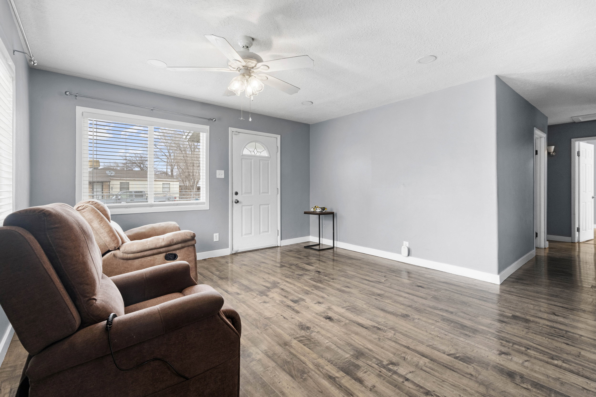 Living area featuring wood finished floors, a ceiling fan, and a textured ceiling