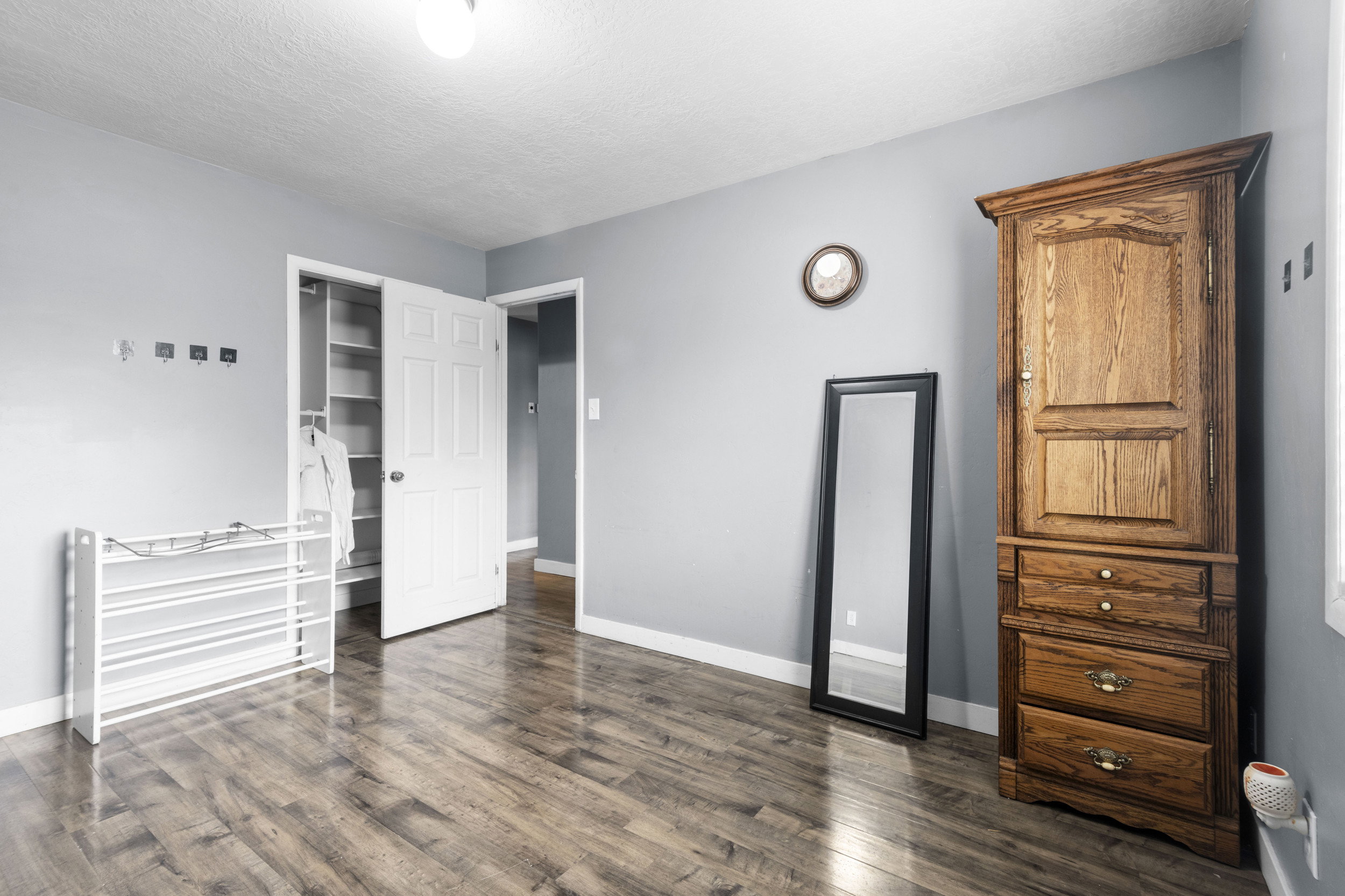 Bedroom with a closet, dark wood-type flooring, and a textured ceiling
