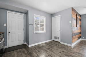 Entryway featuring baseboards and dark wood finished floors