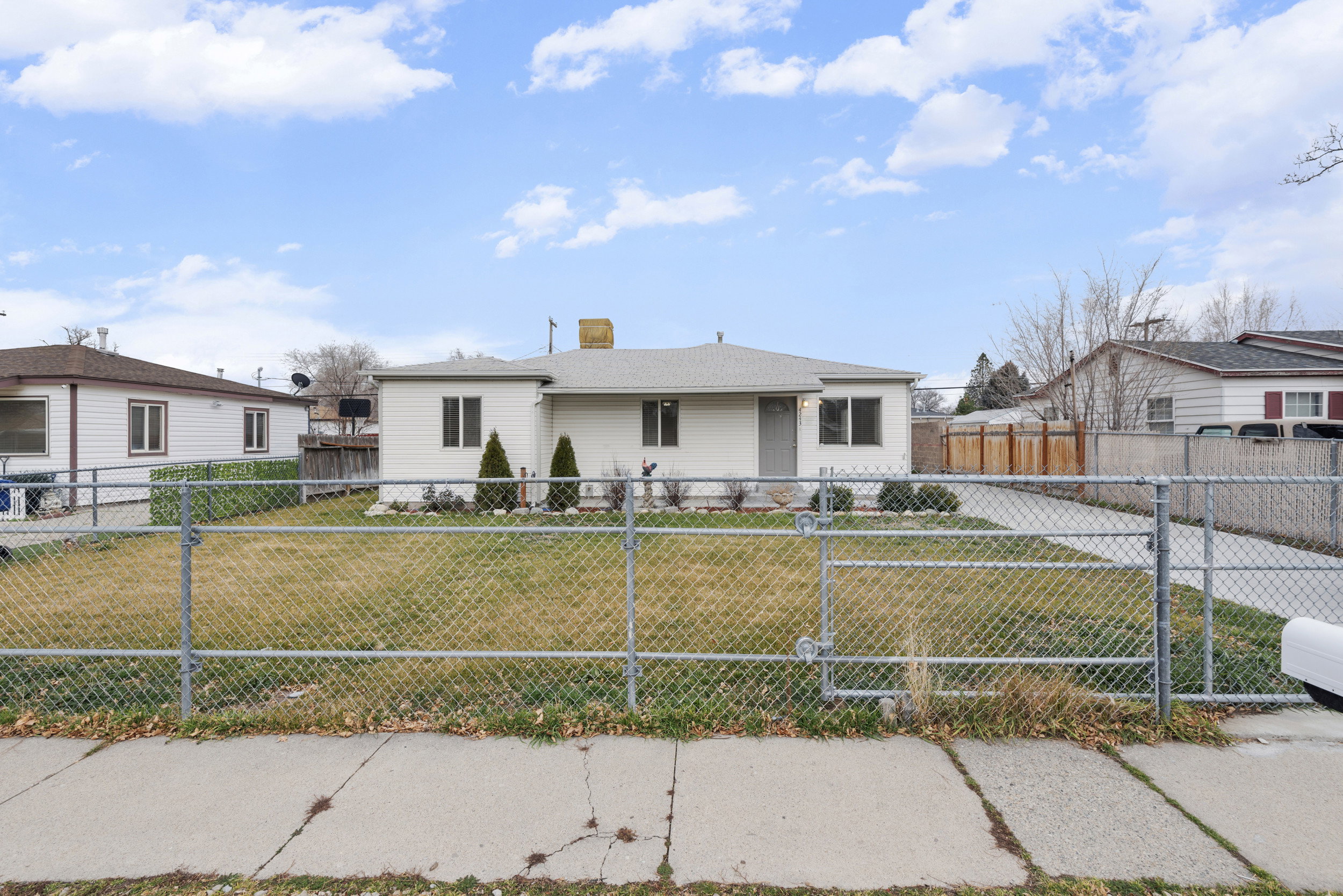 Bungalow-style home featuring a chimney and a fenced front yard