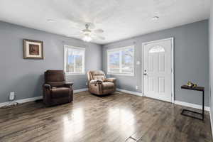 Sitting room featuring a textured ceiling, a ceiling fan, and wood finished floors