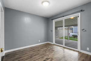 Unfurnished room featuring baseboards and dark wood finished floors