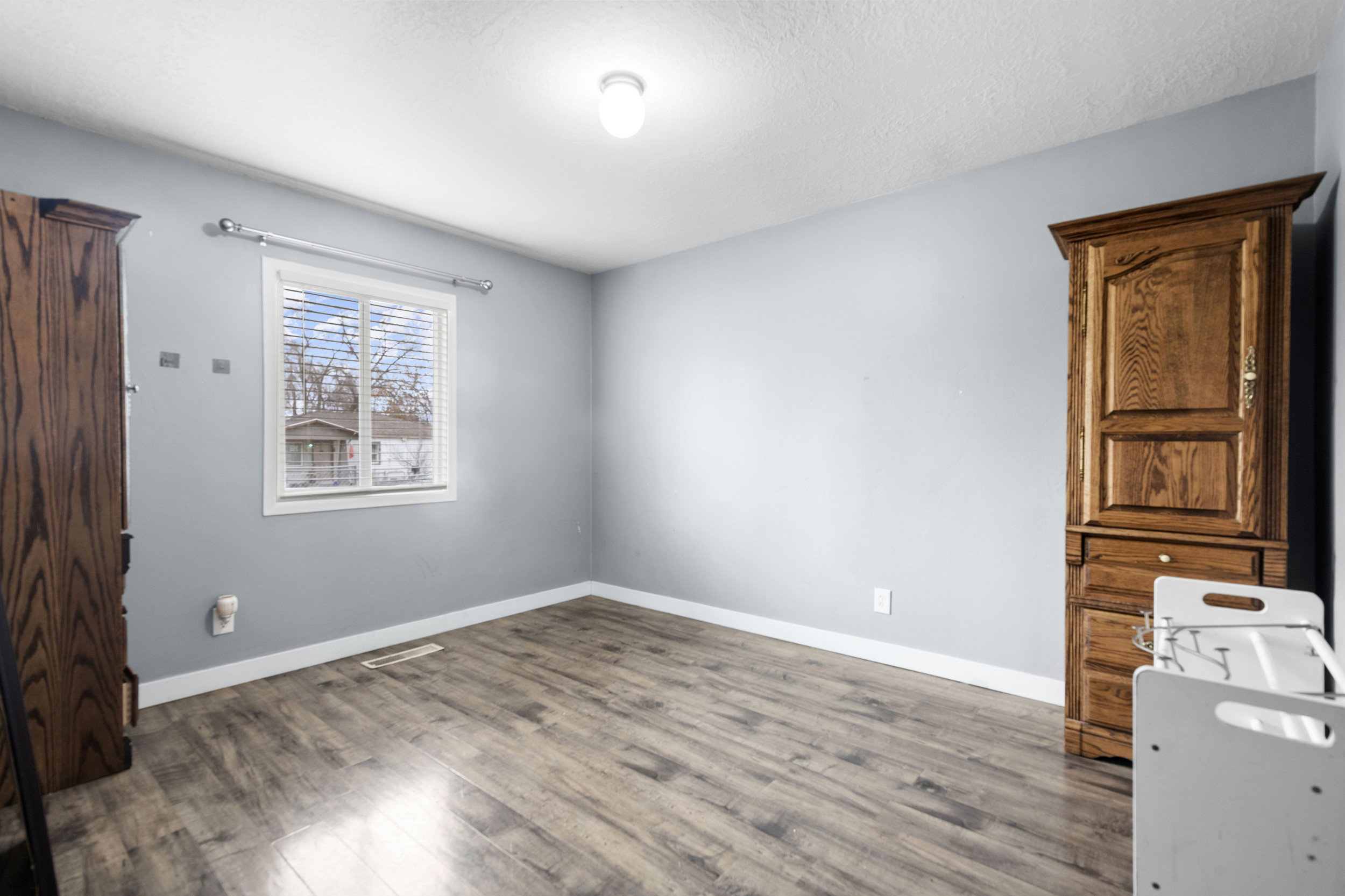 Unfurnished bedroom with wood finished floors and a textured ceiling