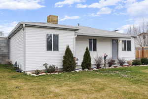 View of front of house featuring a shingled roof and a chimney