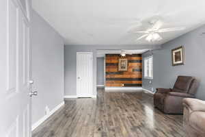 Living area featuring dark wood finished floors and ceiling fan