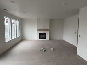 Unfurnished living room featuring a large fireplace and wood finished floors