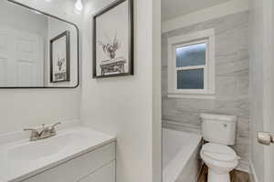Full bath with vanity and tile walls