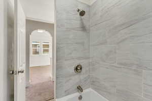 Bathroom with shower / bath combination and light carpet