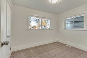 Empty room with light carpet and baseboards