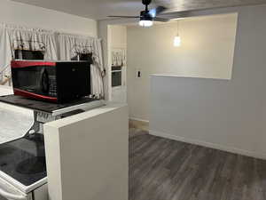 Kitchen with black microwave, a ceiling fan, and dark wood finished floors