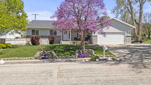 Ranch-style house with brick siding, driveway, covered porch, and an attached garage