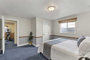 Bedroom featuring a textured ceiling and carpet
