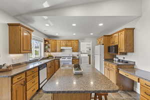 Kitchen with open shelves, recessed lighting, dark stone counters, white appliances, and washer / clothes dryer