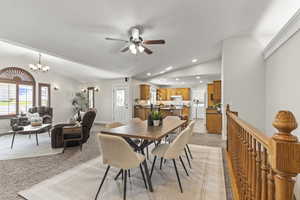 Dining space featuring light carpet, vaulted ceiling, recessed lighting, a chandelier, and ceiling fan