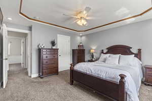 Bedroom with light carpet, ceiling fan, a tray ceiling, and recessed lighting