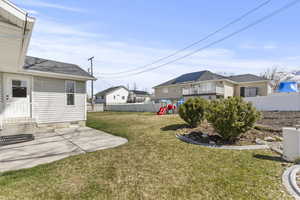 Fenced backyard with a patio and a playground