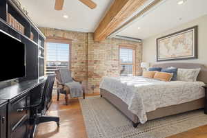 Bedroom featuring light wood-type flooring, brick wall, ceiling fan, and recessed lighting