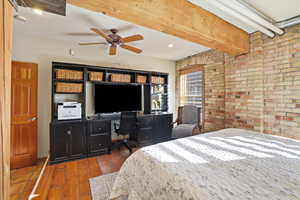 Bedroom featuring brick wall, dark wood-type flooring, a desk, a ceiling fan, and recessed lighting