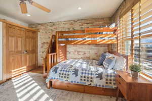 Bedroom featuring brick wall, recessed lighting, and a ceiling fan