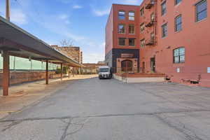 View of building exterior with covered and uncovered parking