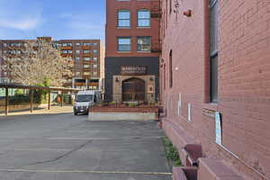 View of apartment building / complex featuring uncovered parking