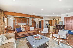 Living room featuring arched walkways, recessed lighting, and beamed ceiling