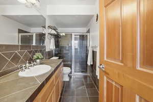 Full bath with vanity, a shower stall, and backsplash