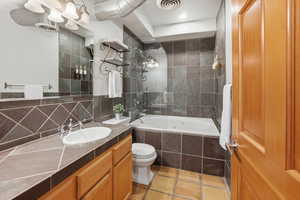Full bathroom with vanity, tiled shower / bath, and tasteful backsplash