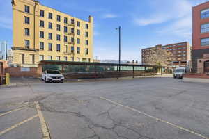 View of building exterior featuring covered and uncovered parking and a mountain view