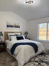 Carpeted bedroom with lofted ceiling and a textured ceiling