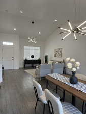 Dining space with a chandelier, vaulted ceiling, dark wood-style floors, and recessed lighting