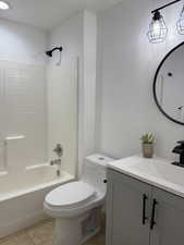 Bathroom with vanity, shower / tub combination, and light tile patterned floors