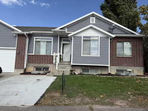 Single story home with a front lawn, brick siding, and roof with shingles