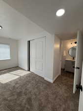 Unfurnished bedroom with carpet floors, a closet, a textured ceiling, and recessed lighting