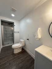 Bathroom with vanity, a stall shower, a textured ceiling, dark wood-style flooring, and recessed lighting