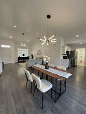 Dining area featuring lofted ceiling, recessed lighting, dark wood finished floors, and a chandelier