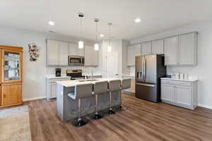 Gray shaker cabinets, quartz countertops, composite granite sink, slate gray stainless steel appliances, soft-close cabinetry, under-cabinet lighting, pull-out spice rack, roll-out trash cans, USB outlets, and an upgraded pantry with added storage and an