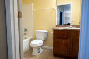 Full bath with light tile patterned flooring, vanity, and bathtub / shower combination