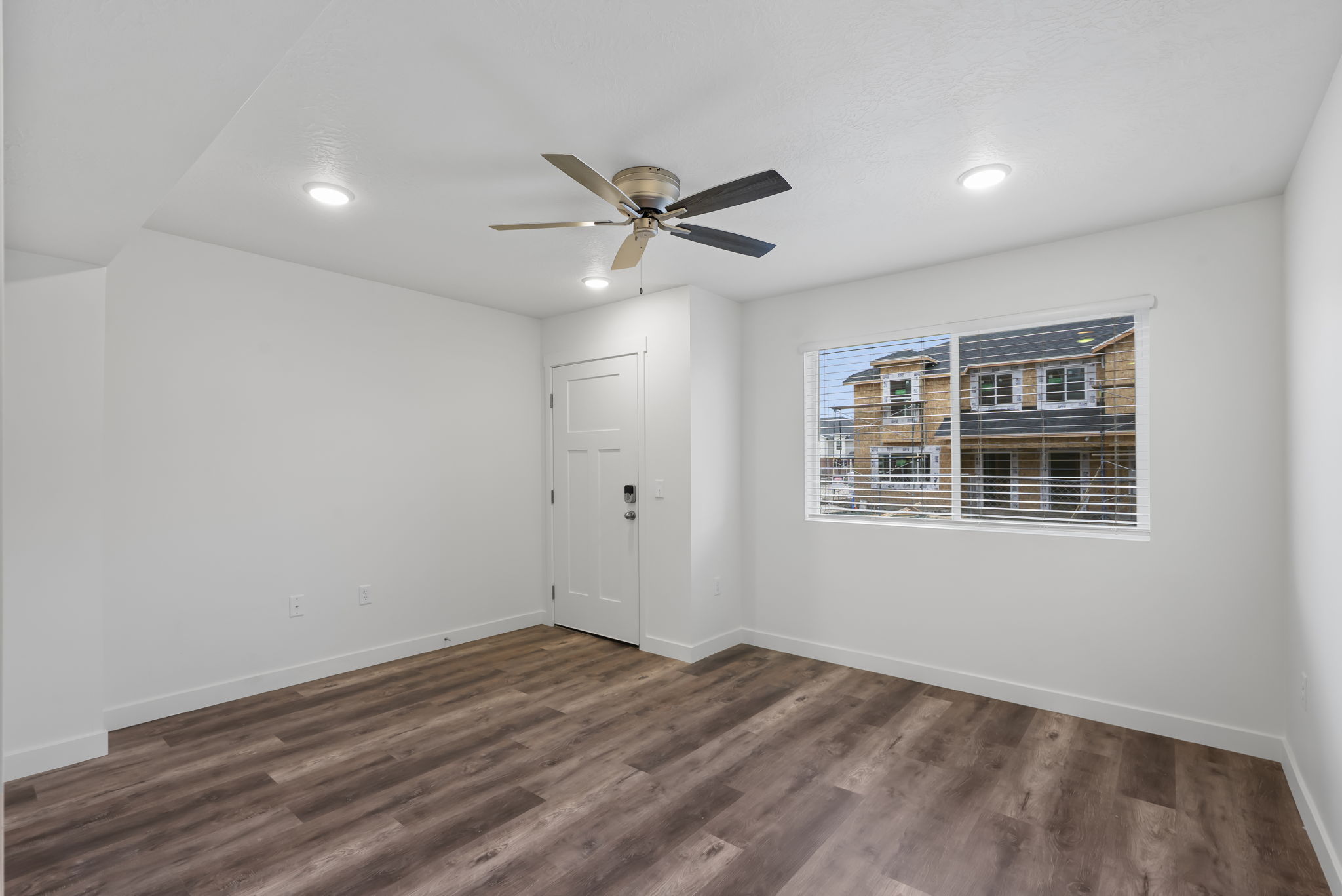 Living room featuring dark wood-style floors, ceiling fan, and recessed lighting