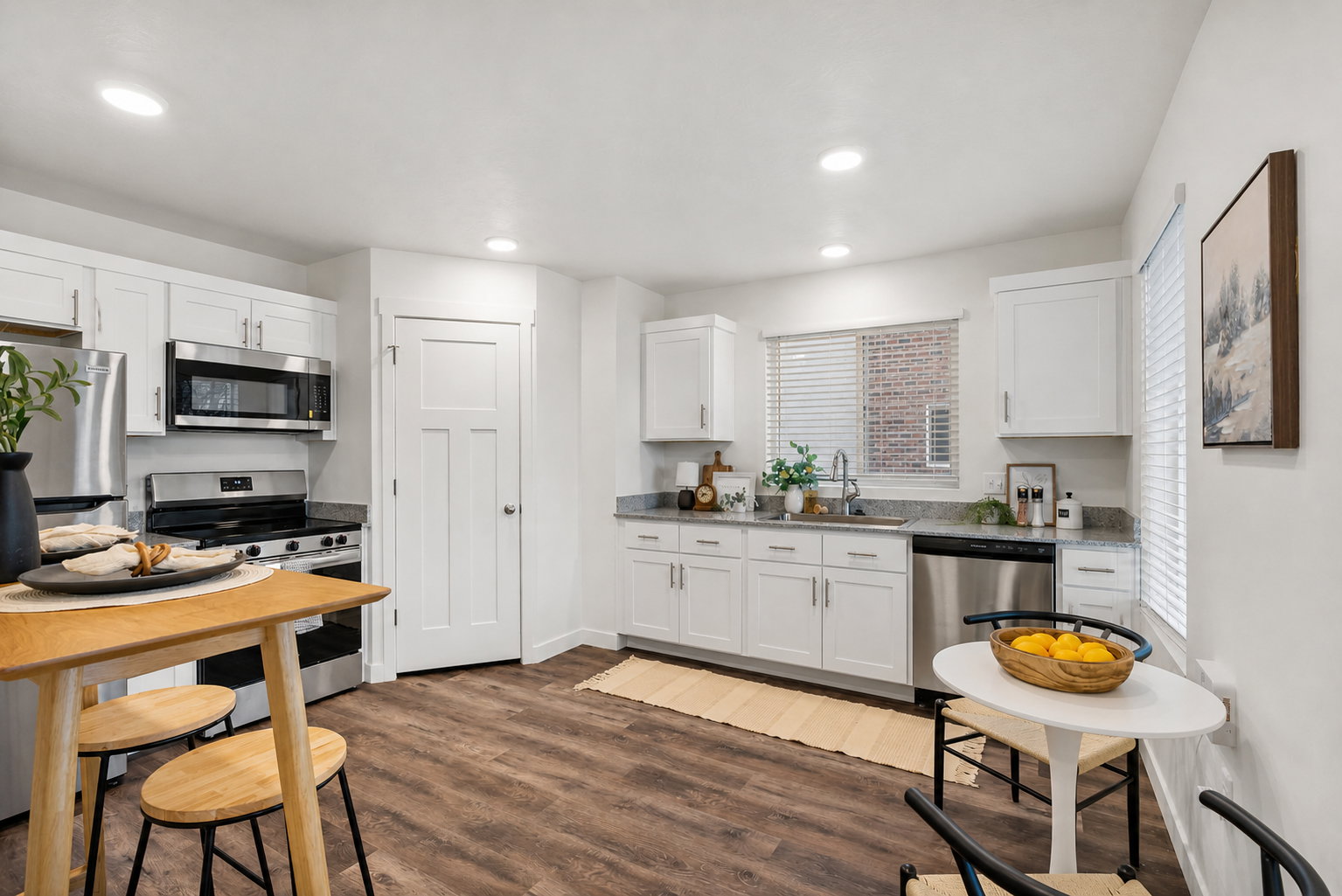 Kitchen featuring stainless steel appliances, white cabinets, dark wood-type flooring, and recessed lighting