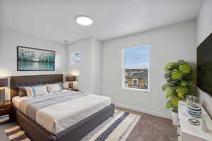 Bedroom with baseboards and dark colored carpet