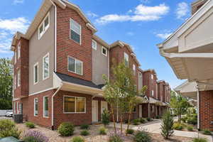 View of front of house featuring brick siding and stucco siding