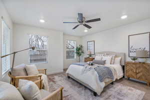 Carpeted primary bedroom featuring a ceiling fan and recessed lighting