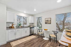 Bar area featuring white cabinetry, dark wood finished floors, dishwasher, dark stone countertops, and recessed lighting
